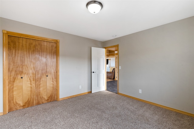 unfurnished bedroom featuring a closet and dark colored carpet