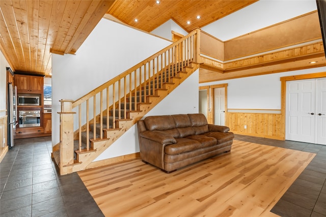 tiled living room with a towering ceiling and wood ceiling