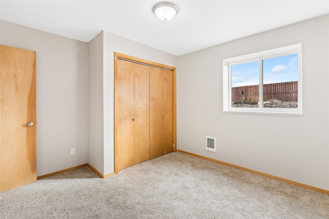 unfurnished bedroom featuring carpet and a closet