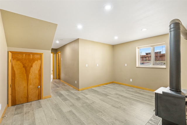 interior space featuring light wood-type flooring and a wood stove