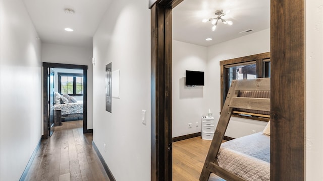 hallway with hardwood / wood-style flooring and a chandelier