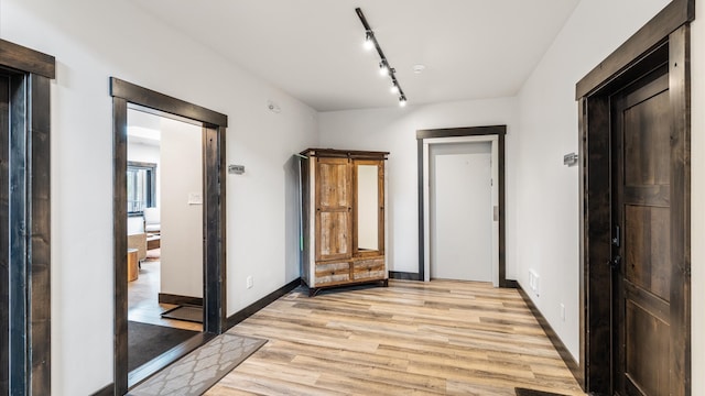 interior space featuring rail lighting and light hardwood / wood-style flooring