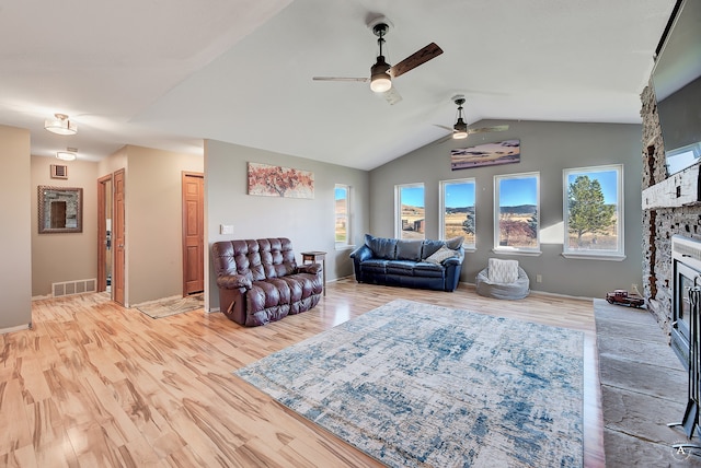 living room with a fireplace, light hardwood / wood-style flooring, ceiling fan, and lofted ceiling