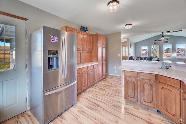 kitchen with stainless steel refrigerator with ice dispenser, light hardwood / wood-style flooring, vaulted ceiling, and plenty of natural light