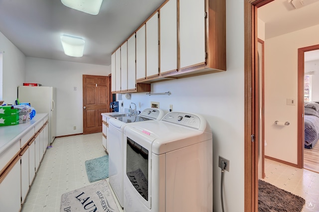 laundry area with washer and dryer and cabinets