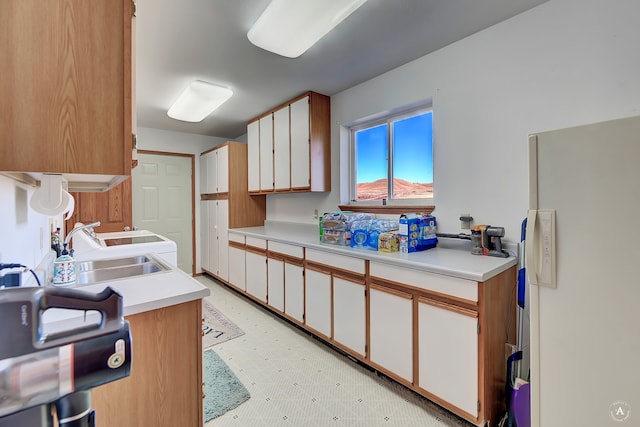 kitchen with white cabinetry, sink, and refrigerator with ice dispenser