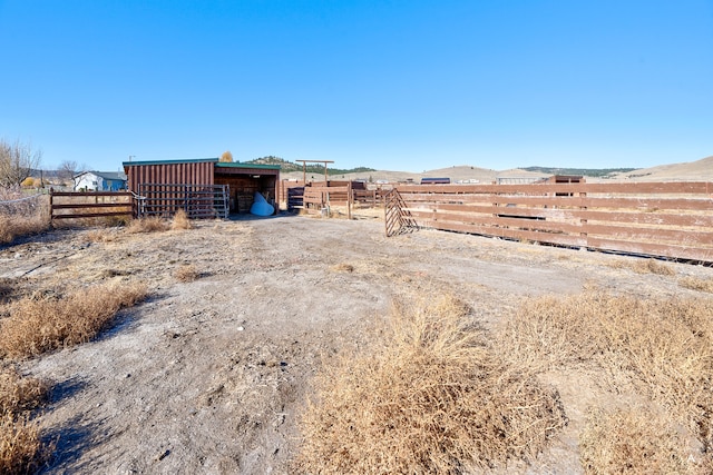 view of yard with a mountain view, a rural view, and an outdoor structure