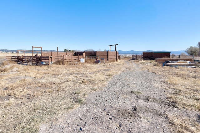 view of yard with a mountain view, a rural view, and an outdoor structure