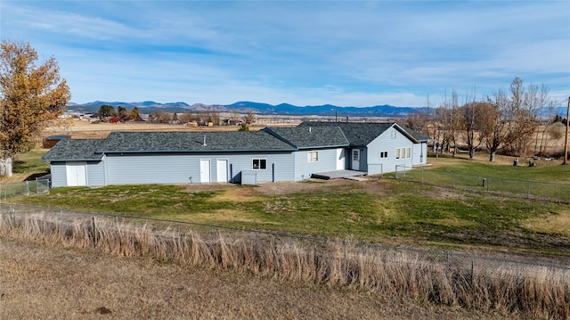 back of property with a lawn and a mountain view