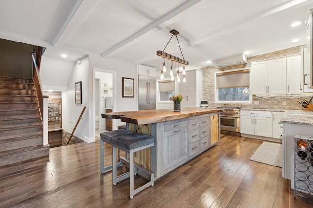 kitchen featuring butcher block counters, white cabinetry, a center island, dark hardwood / wood-style flooring, and pendant lighting