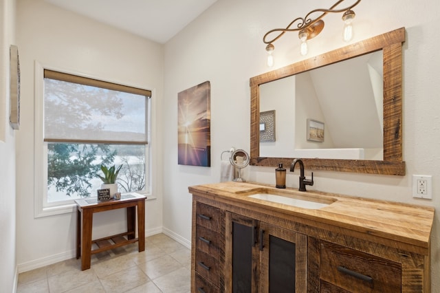 bathroom with tile patterned flooring, vanity, and vaulted ceiling