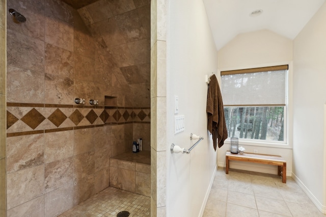 bathroom with a tile shower, tile patterned floors, and lofted ceiling