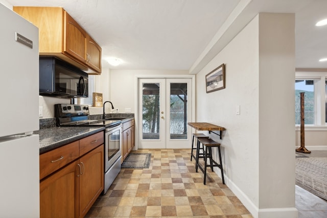 kitchen with french doors, white fridge, stainless steel electric range, and sink