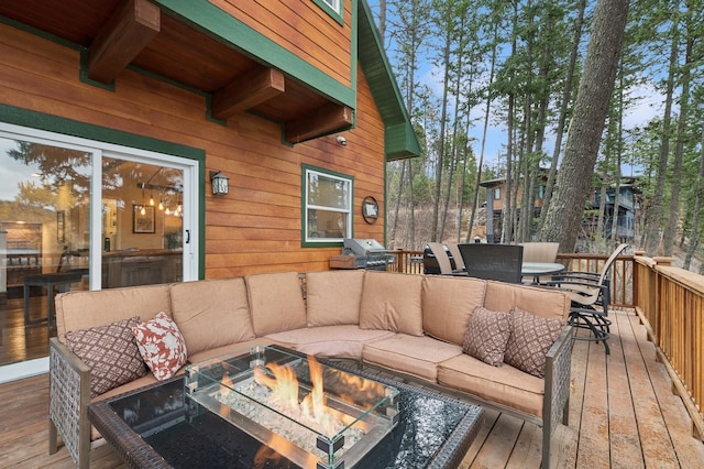 wooden deck with an outdoor fire pit and a grill