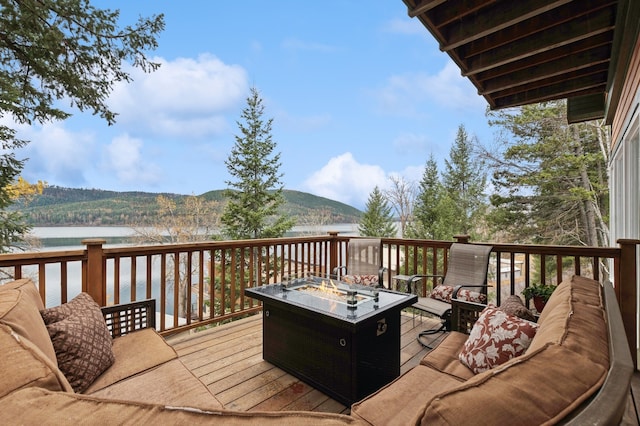 deck featuring an outdoor fire pit and a water and mountain view