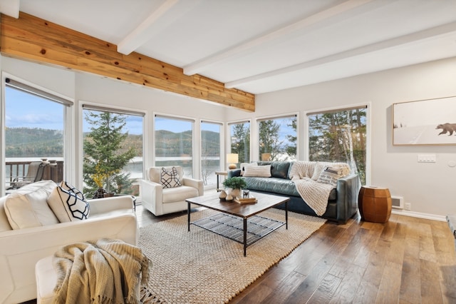 interior space featuring beam ceiling, a water view, and wood-type flooring