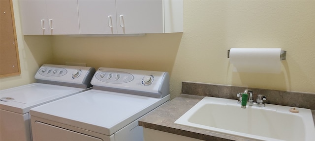 laundry area featuring washer and dryer, cabinets, and sink