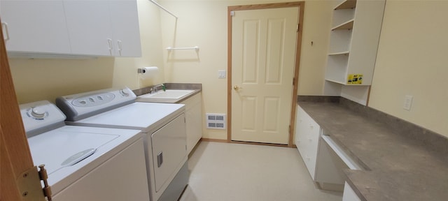 clothes washing area featuring visible vents, washing machine and clothes dryer, cabinet space, and a sink