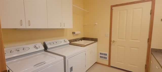 laundry room featuring separate washer and dryer, visible vents, cabinet space, and a sink