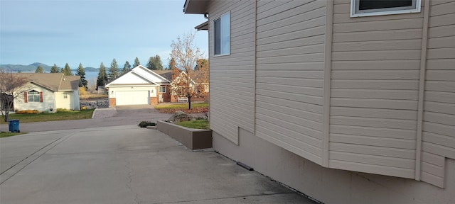 view of side of property featuring driveway, a garage, and a mountain view