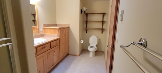 bathroom with baseboards, toilet, and vanity
