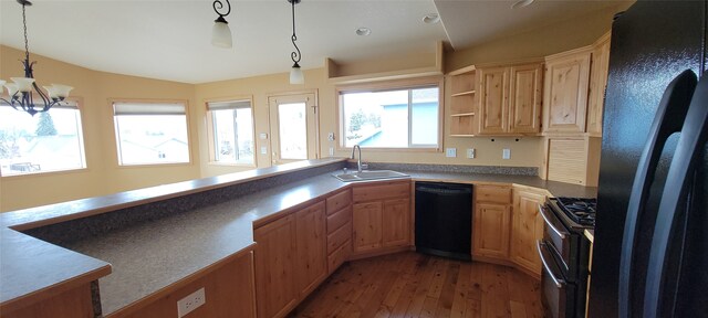 kitchen with a sink, pendant lighting, black appliances, and light wood-style floors