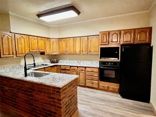 kitchen with black appliances, kitchen peninsula, sink, and light hardwood / wood-style flooring