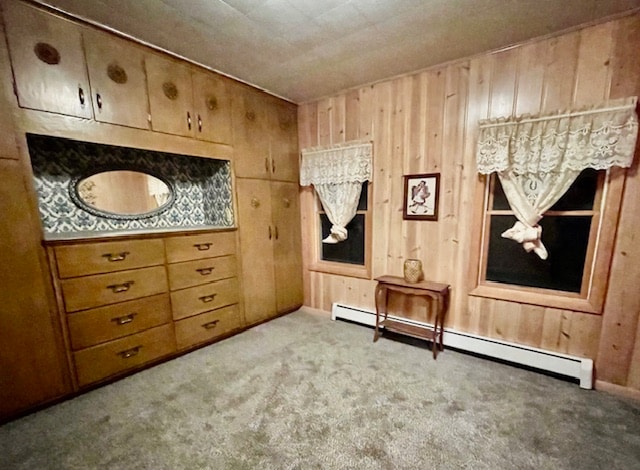 unfurnished bedroom with wooden walls, light colored carpet, and a baseboard heating unit