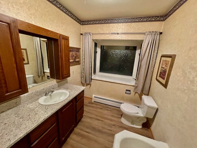 bathroom with vanity, wood-type flooring, a baseboard radiator, and toilet