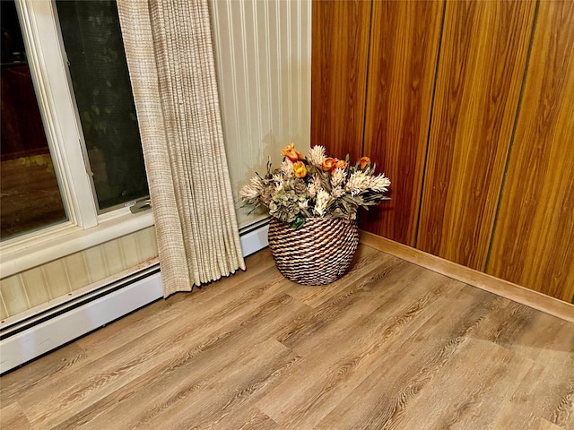details featuring baseboard heating and hardwood / wood-style flooring