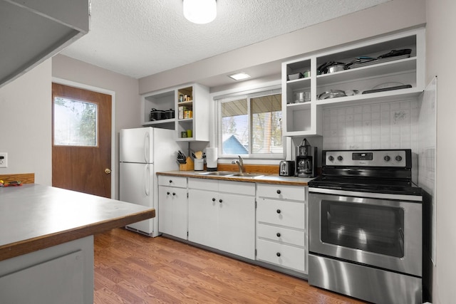 121 Mill Ave, Whitefish, MT 59937 - kitchen with electric stove, open shelves, freestanding refrigerator, a textured ceiling, and white cabinets