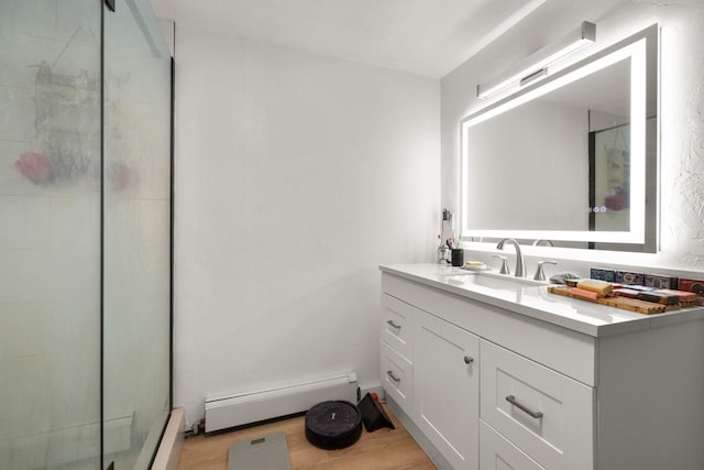 121 Mill Ave, Whitefish, MT 59937 - bathroom featuring baseboard heating, vanity, a shower stall, and wood finished floors