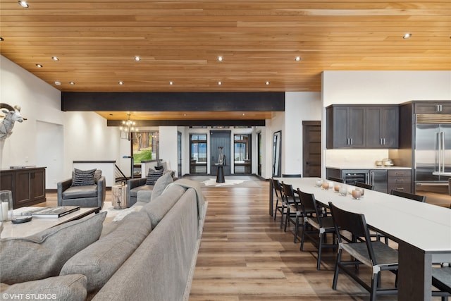 living room with a chandelier, light wood-type flooring, wine cooler, and wooden ceiling