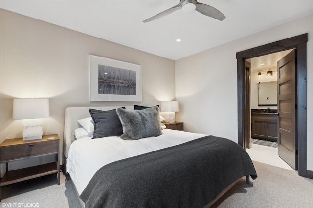 carpeted bedroom with ensuite bath, ceiling fan, and sink