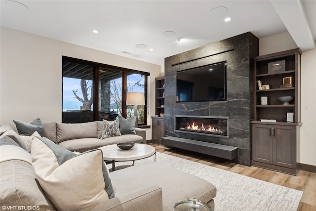 living room with a fireplace and light hardwood / wood-style flooring