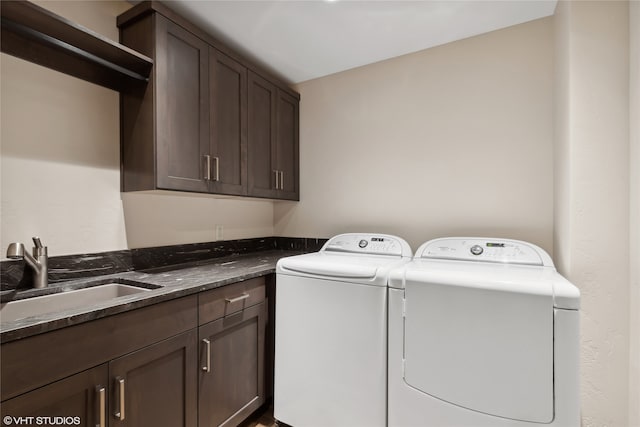 laundry area featuring cabinets, separate washer and dryer, and sink