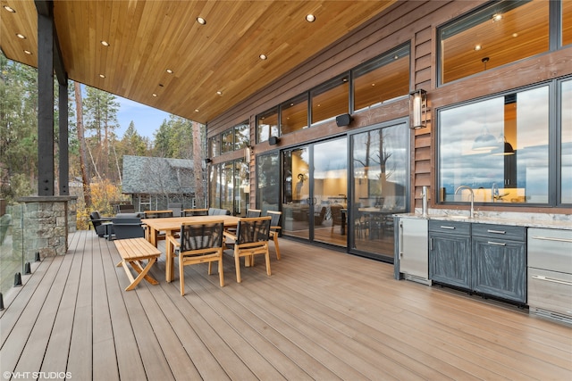 deck at dusk featuring an outdoor kitchen