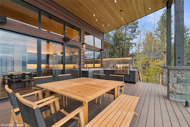 deck at dusk with area for grilling and a grill