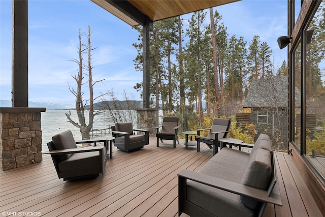 wooden terrace featuring outdoor lounge area and a water view