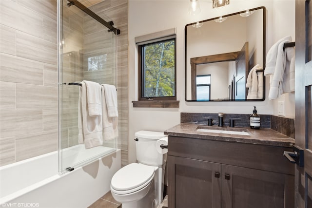 full bathroom with tile patterned flooring, vanity, toilet, and enclosed tub / shower combo