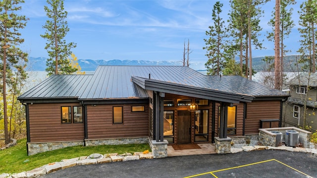 rear view of house featuring central AC and a mountain view