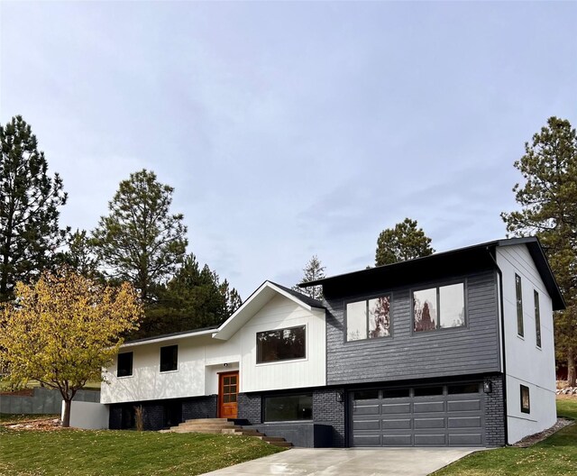 bi-level home with a garage and a front yard