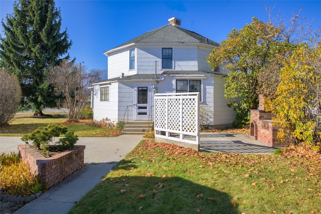 rear view of property with a lawn