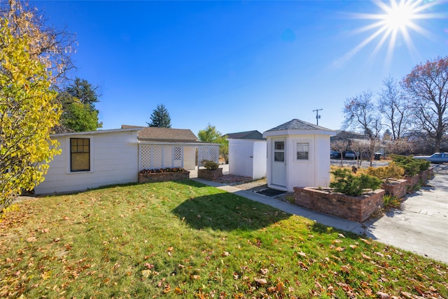 back of property featuring a yard and a storage shed