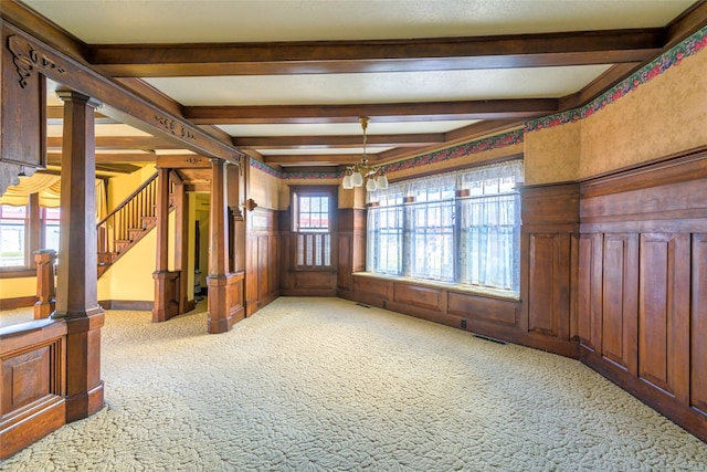 unfurnished room featuring carpet, beam ceiling, and plenty of natural light