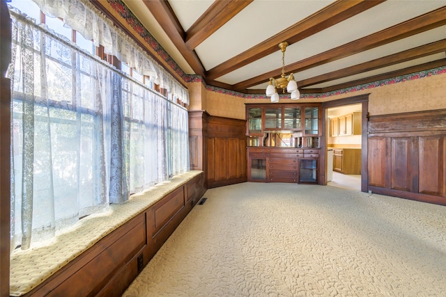 sitting room with beamed ceiling and an inviting chandelier