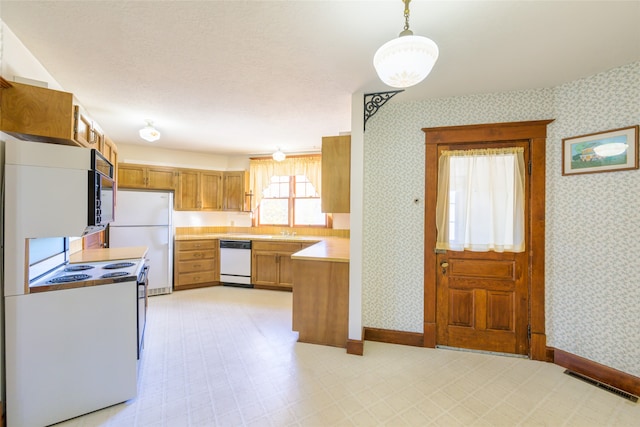 kitchen featuring white appliances and hanging light fixtures