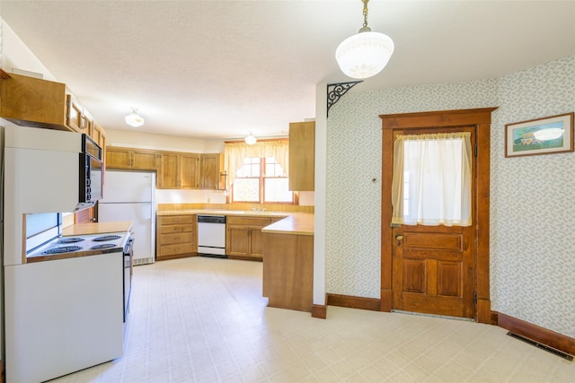200 N 5th St, Hamilton, MT 59840 - kitchen featuring white appliances, wallpapered walls, light countertops, baseboards, and brown cabinets