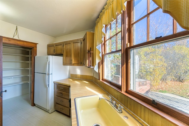 200 N 5th St, Hamilton, MT 59840 - kitchen with freestanding refrigerator, light countertops, healthy amount of natural light, and brown cabinets