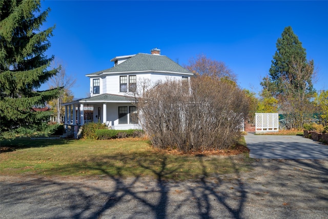 view of front of property with covered porch and a front yard